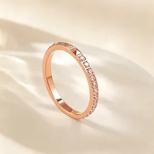 Detailansicht eines roségoldenen Titanstahlrings mit Nieten und klaren Strass