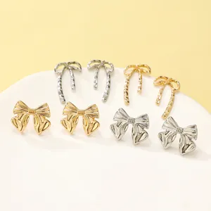 Close-up detail of stylish gold and silver metal bow stud earrings in various designs