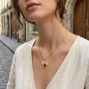 Close-up of elegant gold heart-shaped pendant necklace with red and white zircon stones