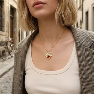 Elegant heart-shaped gold necklace with red and white zircons worn on a model.