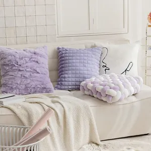 Dettaglio di cuscino intrecciato in velluto viola e cuscini decorativi su divano