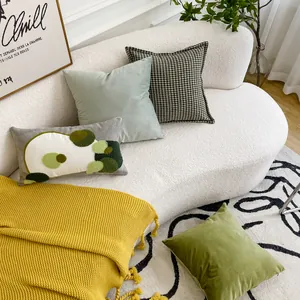 Cuscini in velluto e pied-de-poule con plaid giallo su un divano bianco stile lifestyle