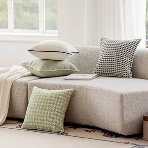 Assortimento di cuscini in velluto stile nordico disposti su un divano moderno