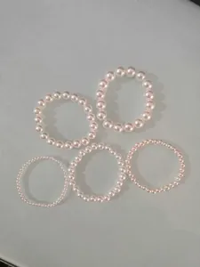 Collection of five elegant imitation pearl elastic bracelets in various sizes for daily wear
