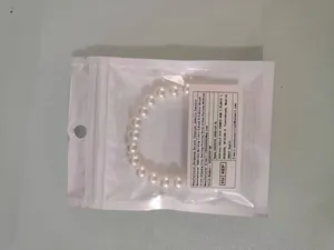 Close-up of a faux pearl elastic bracelet in transparent retail packaging