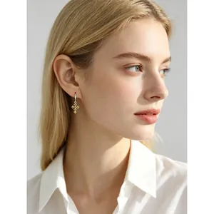 Élégantes boucles d'oreilles créoles en argent s925 avec zircons jaunes sur un modèle