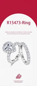 Primer plano detallado de anillo halo de moissanita pera y alianza de eternidad en plata de ley