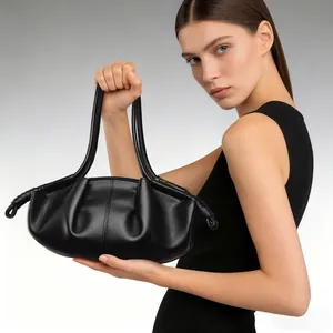 Elegante zwarte wolken handtas met minimalistisch geplooid leren ontwerp op een model