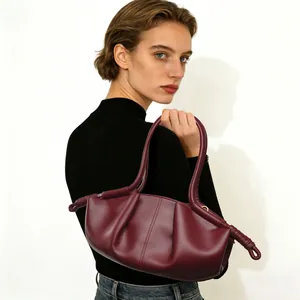 Model met een chique bordeauxrode geplooide wolkschoudertas voor een minimalistische look