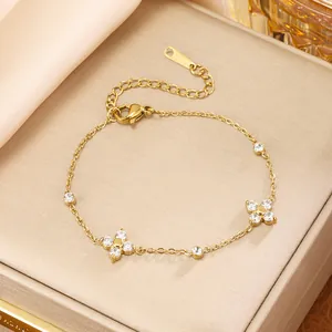 Close-up of elegant gold four-leaf clover bracelet with zircon accents on a jewelry box