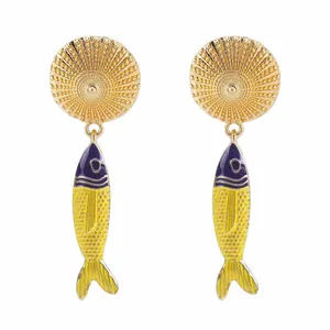 Dettaglio di orecchini a pesce dorati con smalto blu e giallo vibrante dal design.