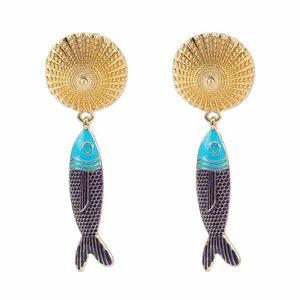 Dettaglio degli orecchini pendenti a pesce bohémien con vivaci scaglie in smalto blu.