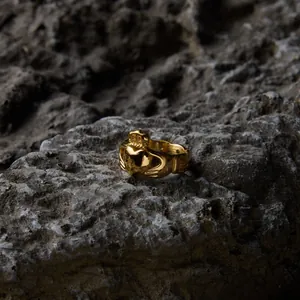 Vue détaillée d'une bague Claddagh en acier titane plaqué or 18 carats sur fond de roche