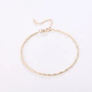 Detalle de una pulsera de cadena torcida minimalista en oro con un cierre de langosta