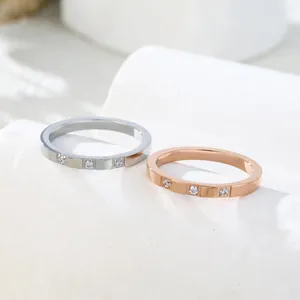 Detailed close-up of silver and rose gold minimalist rings with three inlaid stones.