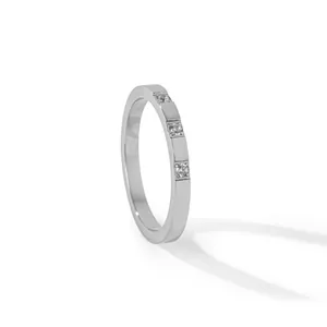 Detailed side view of silver flat-band ring with three sparkling embedded stones