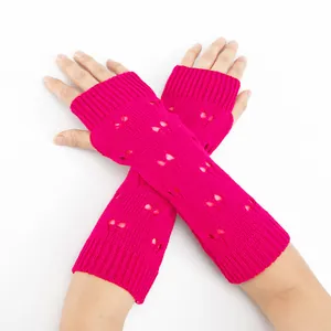 Detailed macro shot of pink knitted fingerless arm warmers with heart pattern motifs