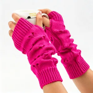 Detail of bright pink knitted arm warmers featuring heart patterns and soft wool texture