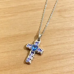 Nahaufnahme einer gotischen Kreuzkette mit lila Emaille und blauem Herz