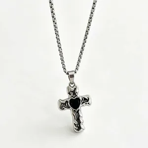 Detaillierte Makroansicht eines gotischen Silberkreuzanhängers mit schwarzem Herzmotiv