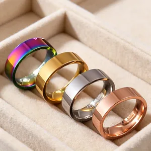 Detail view of 6mm stainless steel band rings in four colors inside a beige jewelry box.