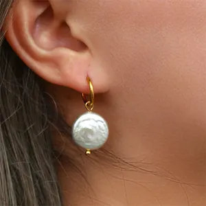 Gros plan sur des boucles d'oreilles créoles en perles baroques plaqué or 18k.