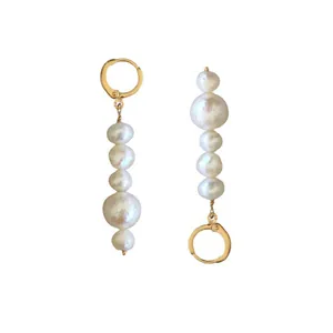 Vue détaillée de boucles d'oreilles en perles baroques et créoles dorées à l'or 18 carats