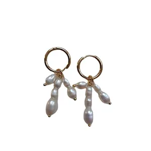 Vue détaillée de boucles d'oreilles créoles dorées avec perles baroques naturelles
