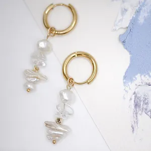 Détail de boucles d'oreilles créoles avec perles baroques naturelles plaquées or 18k