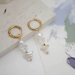 Détail de créoles dorées avec des perles baroques naturelles et éclats de quartz