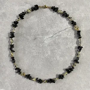 Vue détaillée d'un collier ras du cou en pierres noires concassées et jaspe dalmatien