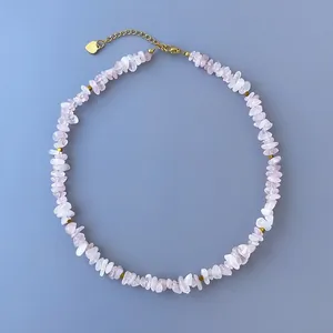 Détail d'un collier en pierre naturelle rose avec accents dorés et fermoir mousqueton