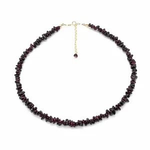 Gros plan d'un collier en éclats de pierres naturelles rouge foncé avec chaîne dorée