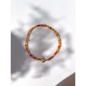 Détail d'un collier en éclats de pierres naturelles colorées avec fermoir toggle doré