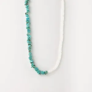 Détail d'un collier composé d'éclats de turquoise et de perles de disque blanches