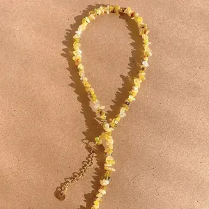 Détail du collier en pierres de tourmaline jaune concassées avec chaîne dorée