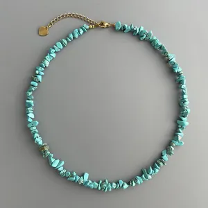 Détails d'un collier en pierres turquoises avec un fermoir doré et charme en cœur