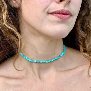 Gros plan d'un collier ras du cou bohème en éclats de turquoise bleue sur un mannequin