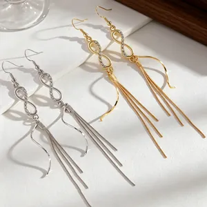 Detailed view of infinity tassel earrings featuring sparkling rhinestones in gold and silver