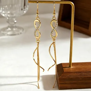 Detailed shot of golden infinity symbol earrings with rhinestones and long tassels