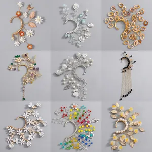 Dettaglio di nove orecchini ear cuff fatti a mano con decorazioni floreali e perle