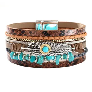 Pulsera multicapa de cuero bohemio con piedras turquesas y un dije de pluma en plata.