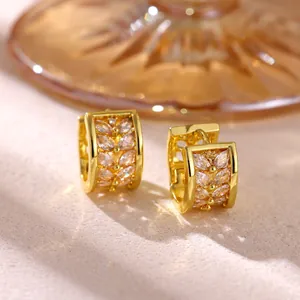 Detailed macro view of gold hoop earrings featuring marquise-cut cubic zirconia leaf pattern