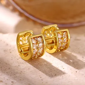 Macro view of gold-plated hoop earrings with leaf-patterned marquise cubic zirconia