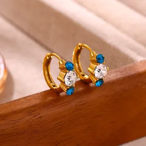 Detailed view of gold hoop earrings with sparkling blue and clear zirconia stones