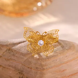 Vista detallada de un anillo de mariposa bañado en oro con alas de filigrana y una circonita.