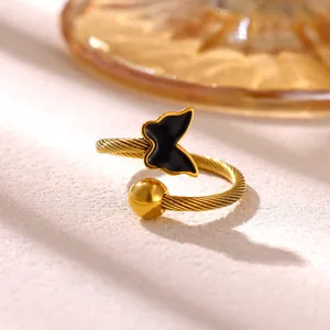 Elegante primer plano de un anillo abierto de mariposa dorado con banda de cable torcido