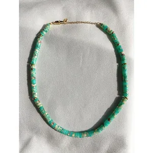 Detailed view of natural green marbled gemstone beaded necklace with golden metal spacers