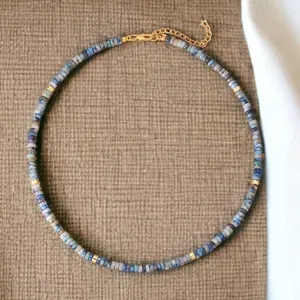 Detailed shot of minimalist natural semi-precious stone beaded choker with golden hardware.