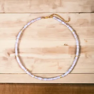 Macro detail of iridescent semi-precious stone beaded necklace with gold-tone metal spacers.